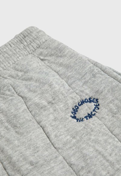 Grå quiltade sweatpants med synlig sömmar, elastisk midja och broderad blå textdetalj. Mjuk textur och avslappnad design.