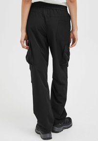Pantaloni cargo neri con una cintura elastica, dotati di tasche laterali e una superficie liscia. Progettati per un fitting rilassato, adatti per un abbigliamento casual.