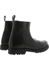 Botines negros de cuero liso con una suela resistente, que cuentan con un corte bajo y tiradores en la parte trasera para facilitar su uso.