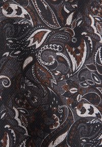 Tessuto scuro a motivi con design paisley a vortice in tonalità bianche, argento e marrone rame, con una trama testurizzata.