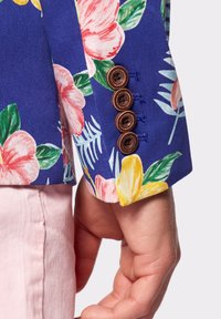 Niebieska rękaw kurtki w kwiatowy wzór z jaskrawymi różowymi i żółtymi kwiatami, z czterema brązowymi guzikami wzdłuż mankietu i zielonymi akcentami liści.