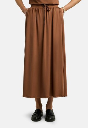 Gonna midi marrone con vita elasticizzata e coulisse, indossata con mocassini neri e mani nelle tasche, vista dalla vita ai piedi.