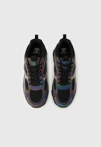 Mustad ja sirelised tossud võrkmaterjalist pealsega, kontrastse kummipõhjaga ja mustade paeltega. Märkimisväärsed kõverad disainielemendid külgedel.