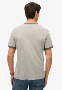 Grijze korte mouwen t-shirt met een ronde hals. De mouwen hebben een contrasterende donkergrijze rand. De stof lijkt zacht en lichtgewicht te zijn.