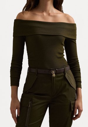 Top verde oliva acanalado, de hombros descubiertos y mangas largas, combinado con pantalones cargo verde oliva de talle alto con bolsillos y cinturón marrón.