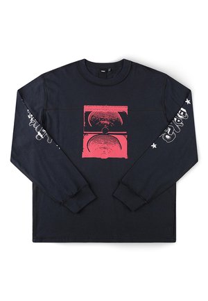 Chemise noire à manches longues avec un graphisme abstrait de haut-parleur rouge sur le devant et du texte stylisé blanc ainsi que des étoiles le long des deux manches.