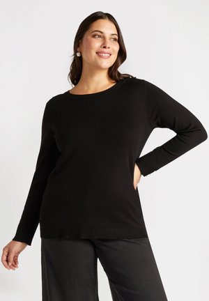 Pull noir à manches longues avec un col rond et des poignets et un ourlet côtelés. Matériau doux ; silhouette ajustée avec une coupe décontractée.