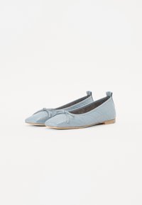 Ballerines matelassées bleu clair avec un bout arrondi, un nœud décoratif et une semelle plate beige. Texture en cuir douce et design minimaliste.