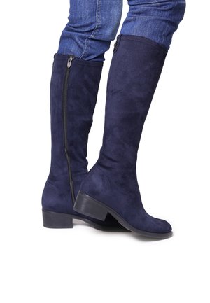 Bottes montantes en faux daim bleu marine avec un petit talon empilé et une fermeture éclair sur le côté. Texture lisse sans motifs ou accents visibles.