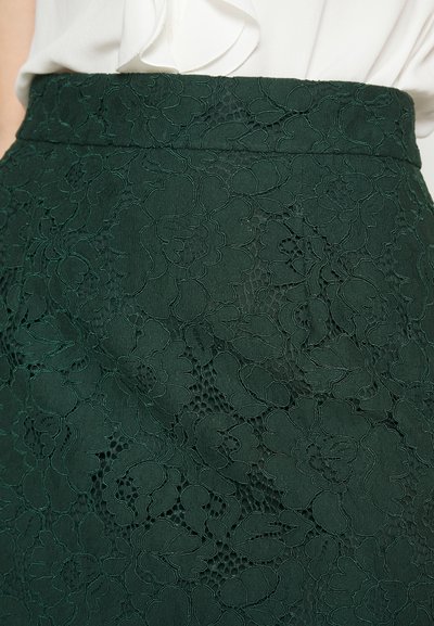 Dunkelgrüner Spitzenrock mit intricaten Blumenmustern, strukturiertem Material und glattem Bund. Das Design zeichnet sich durch geschichtete Spitzen-Details aus.
