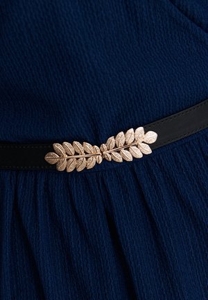 Schwarzer Gürtel mit einer strukturierten Lederoberfläche, der ein zentrales Design aus metallischem Roségoldblatt aufweist, das auf einem dunkelblauen Stoff gesetzt ist.