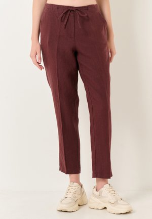 Bordeaux linnen broek met een elastische taille, rechte pijpen en een subtiele textuur, gecombineerd met beige chunky sneakers.