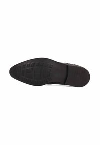 Suela de zapato de goma negra con una superficie texturizada, que presenta patrones rectangulares y ranuras para mejorar la tracción. Forma oblonga con una parte delantera ligeramente afilada.