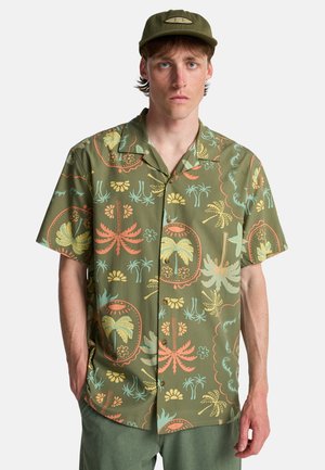Korte mouw olijfgroen overhemd met kleurrijke tropische patronen, knopen aan de voorkant en een ontspannen pasvorm. Draagt daarbij bijpassende broek.