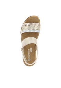 Sandale dorée claire avec une bande métallique tissée, une sangle de cheville réglable et une semelle intérieure rembourrée. Dessus en simili-suède doux avec une semelle beige.