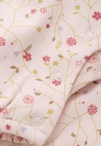 Jasnoróżowa, żebrowana tkanina z kwiatowym nadrukiem w odcieniach różu, zieleni i lawendy. Zawiera zapięcia na zatrzask i ma miękką teksturę.