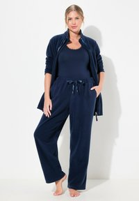 Tummansininen fleecetakki ja -housut, joissa on vetoketjullinen takki ja narusäädettävät housut rentoa istuvuutta ja sileää tekstuuria varten.