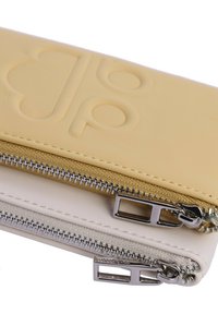 Billetera de cuero amarilla y blanca con compartimentos de doble cremallera. Presenta un logotipo en relieve y herrajes plateados. Textura suave con un diseño aerodinámico.
