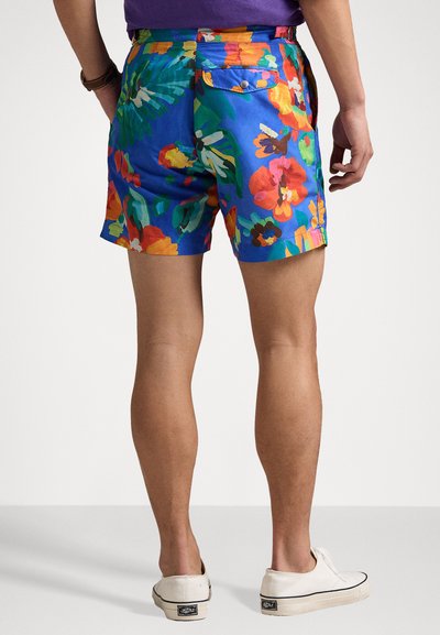 Blumenmuster-Shorts mit lebendigem blauen Grund, die mit roten, orangefarbenen und grünen Blumen verziert sind. Hergestellt aus leichtem Stoff, mit Gesäßtaschen.