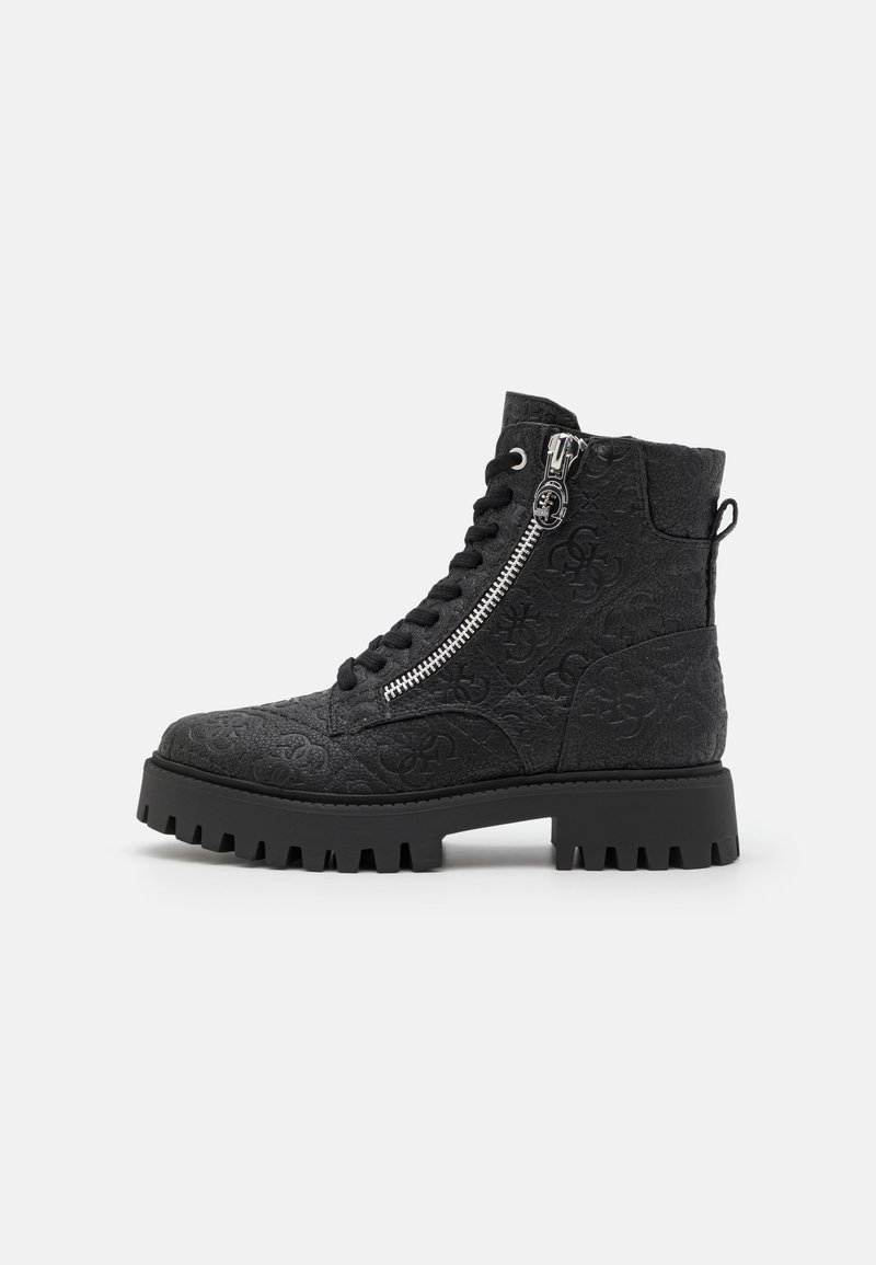 Bottes noires à la cheville avec un motif texturé, dotées de lacets et d'une fermeture éclair sur le côté, semelle en caoutchouc épaisse avec des crampons prononcés, et un design durable.