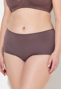 Bruine hoge taille slip gemaakt van zachte stof, met een eenvoudig ontwerp, een gladde textuur en een elastische tailleband.