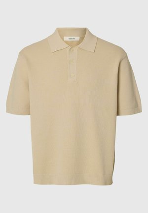 Polo corta a maniche corte color beige in maglia con collo e tre bottoni, polsini e orlo a coste, tessuto strutturato.