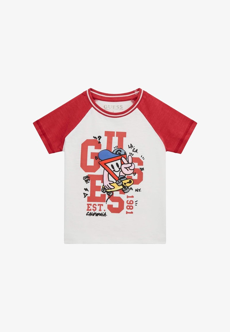 T-shirt enfant manches courtes blanc et rouge avec un personnage de dessin animé tenant un skateboard et un grand texte rouge "GUESS" sur le devant.