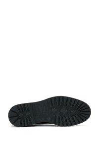 Zwarte rubberen schoenzool met een gestructureerd oppervlak en opvallende loopvlakpatronen en contouren voor grip en stabiliteit.