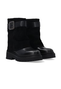 Schwarze Knöchelstiefel aus einer Kombination von glattem Leder und Wildleder. Das Design umfasst einen breiten Lederriemen und silberne Schnallenakzente.