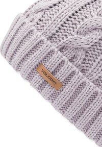 Gorro de punto de color púrpura claro con un diseño de trenzas texturizadas. Presenta una etiqueta de cuero marrón con la inscripción "VOLCOM" en relieve. Puño acanalado en la base.