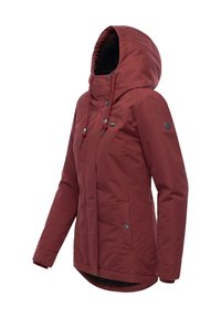 Red, waterproof jacket with a fleece-lined hood, zip closure, snap buttons, and two side pockets. Features a slightly curved hemline.