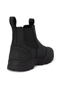 Botas de tobillo negras con un upper de cuero liso, paneles laterales elásticos y un acento texturizado negro. Suela de goma resistente para tracción.