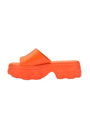 Chancla de goma naranja con una correa superior ancha y una suela gruesa y texturizada que presenta acentos elevados y una forma redondeada.