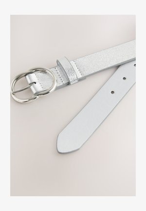 Sidabrinis dirbtinės odos diržas su tekstūruotu paviršiumi, turintis apvalią metalinę sagtį ir reguliuojamas skylutes. Lygi apatinė pusė, plokščias galas.