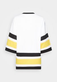 Bílé tričko s černými, bílými a žlutými vodorovnými pruhy. Krátké rukávy a kulatý výstřih. Texturovaná tkanina s sportovním designem.