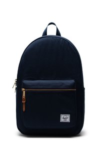 Zaino in tela navy con parte superiore arrotondata, tasca frontale con zip, tirazip in pelle marrone e etichetta del marchio bianca. Texture liscia e design minimalista.