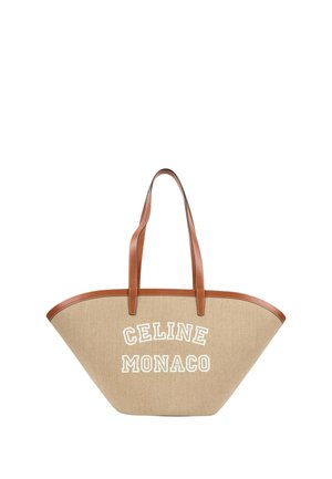 Sac cabas trapèze beige avec des poignées et bordures en cuir marron, avec un texte blanc ""CELINE MONACO"" sur le devant.