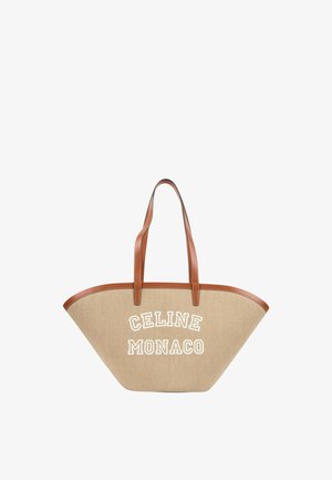 Sac cabas trapèze beige avec des poignées et bordures en cuir marron, avec un texte blanc ""CELINE MONACO"" sur le devant.