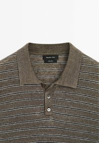 Polo en lin rayé marron et gris avec un col côtelé et trois boutons sur la patte de boutonnage.