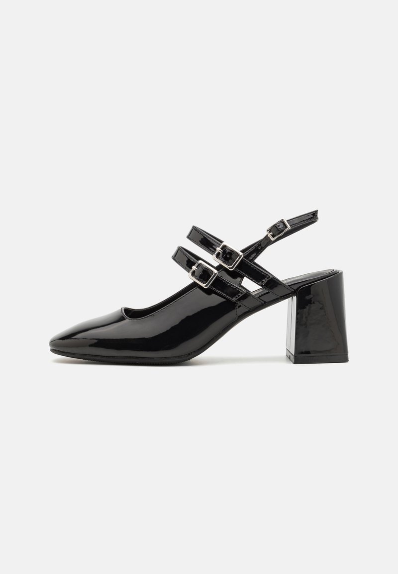 Tacones slingback de charol negro con punta afilada, dos correas con hebillas y un tacón grueso. Textura suave con acabado brillante.
