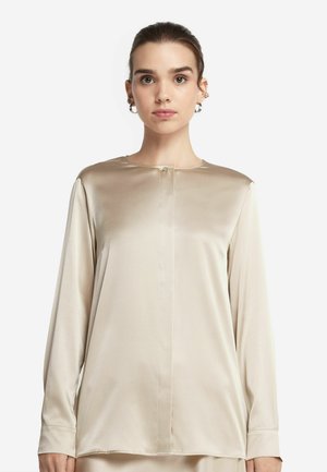 Blusa beige a maniche lunghe realizzata in tessuto satinato, con scollatura rotonda, dettaglio dei bottoni frontali e una leggera lucentezza, dal fit rilassato.
