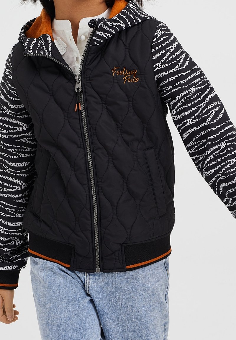 Giacca nera trapuntata con maniche a motivo zebra, dettagli arancioni e zip frontale. Presenta un cappuccio e polsini e orlo a costine.