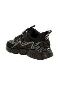 Scarpa sportiva nera con tomaia in rete e suola nera testurizzata. Caratterizzata da due cinturini in velcro e accenti a strisce sul tallone.