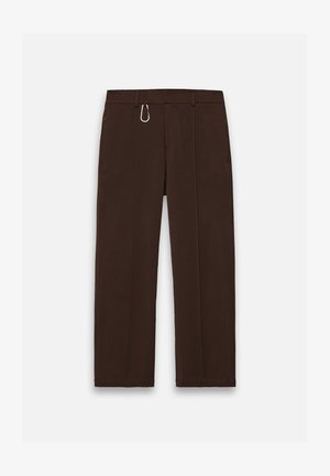 Braune, weit geschnittene Hosen aus glattem Stoff mit einem Reißverschluss und einem Karabinerclip als auffälligem Akzent, ausgestattet mit zwei Seitentaschen.