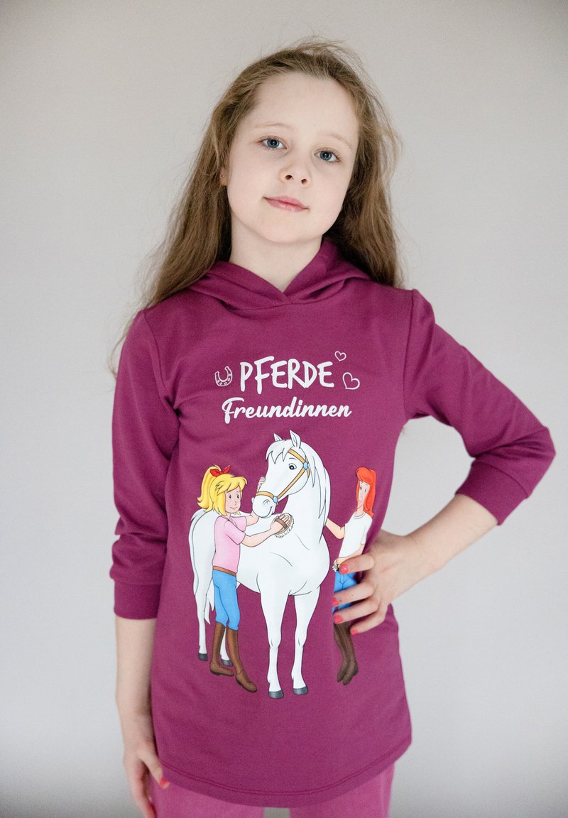 Felpa con cappuccio color marrone bordeaux che presenta ragazze in stile cartone animato e un cavallo bianco. Il design include il testo "Pferde Freundinnen" sopra l'illustrazione.