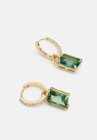 Des boucles d'oreilles en or en forme de hoop présentent un pendentif rectangulaire en pierre précieuse verte, avec une bande de petits cristaux transparents soulignant le hoop.