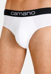 Slip in cotone bianco con elastico nero in vita, che presenta il nome del marchio "camano" in testo bianco, evidenziando un design liscio e aderente.