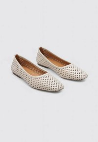 Ballerines beiges avec un bout pointu et un design perforé découpé. Tige texturée et intérieur en cuir lisse, semelle plate pour le confort.