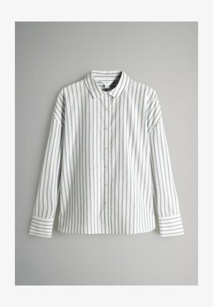 Camicia bianca con bottoni, a righe verticali nere e sottili, colletto e maniche lunghe con polsini a righe contrastanti.