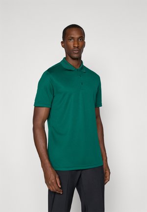 Chemise polo verte en matériau doux, avec un col classique et une patte de boutonnage à trois boutons. Coupe ajustée et manches courtes.